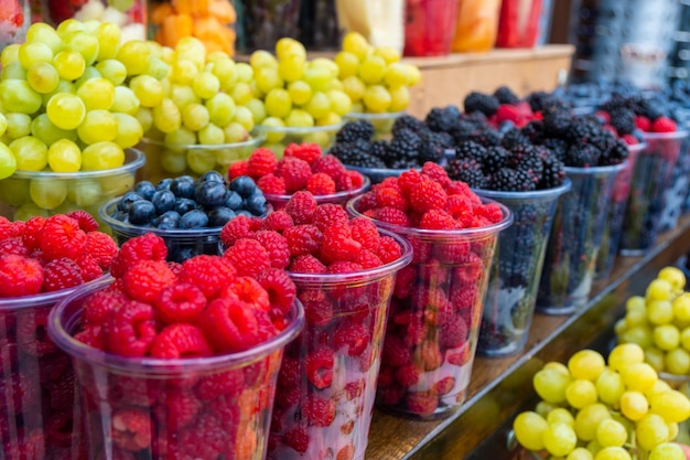 Fresh juicy berries on farmer market Colorful different fruit sets at street cafe