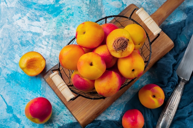 Fresh juicy fruit nectarines in metal grid on blue concrete.  