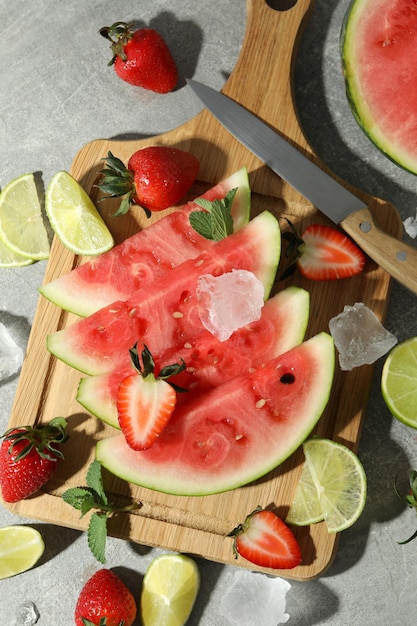 Fresh and juicy fruits with ice on gray textured background