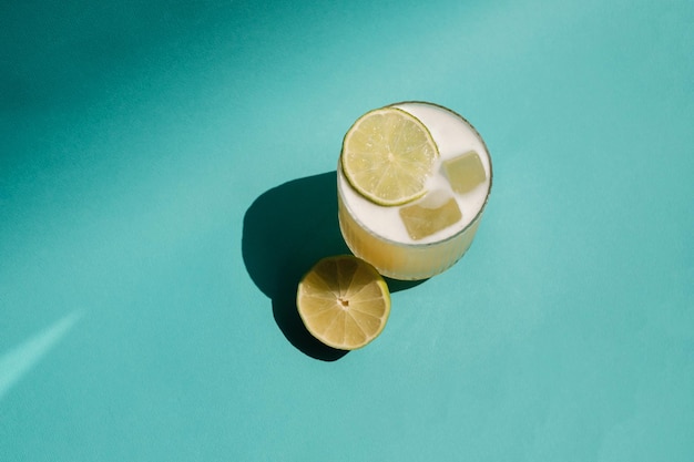 Fresh juicy lime cocktail on blue background