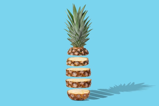 Fresh juicy pineapple in flight cut into rings On a blue background