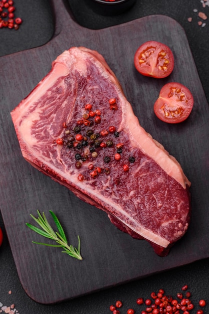 Fresh juicy raw new york beef steak with salt spices and herbs