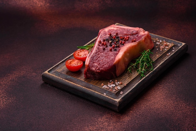 Fresh juicy raw new york beef steak with salt spices and herbs