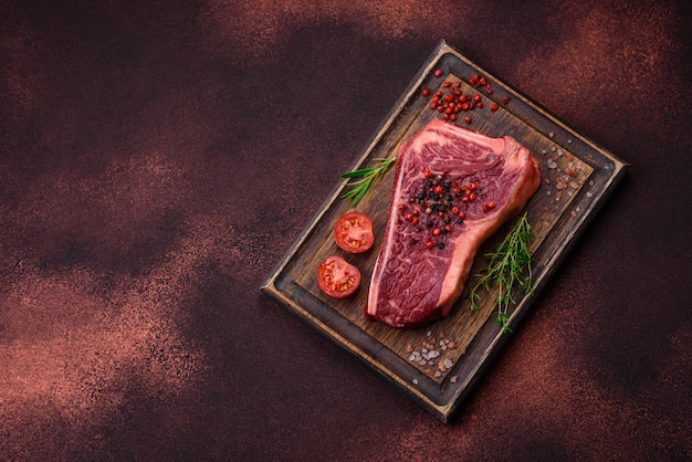 Fresh juicy raw new york beef steak with salt spices and herbs