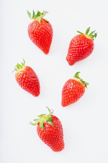 Fresh juicy strawberries isolated over white desk. Top view.