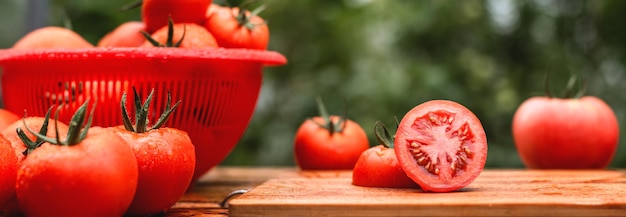 Fresh juicy tomatoes covered with water drops on a wooden table