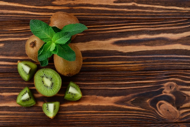 Fresh kiwi fruits on a wooden table. Space for text or design.