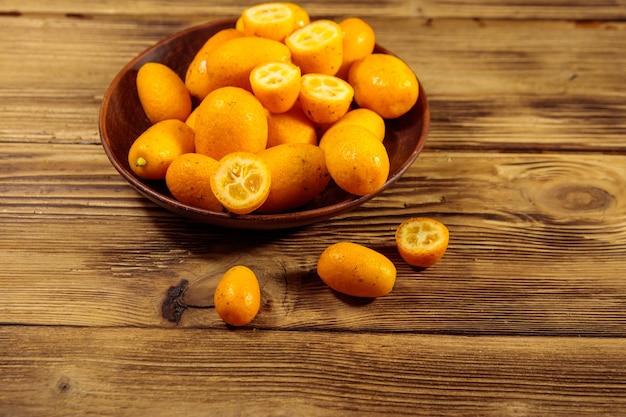 Fresh kumquat fruits on wooden table