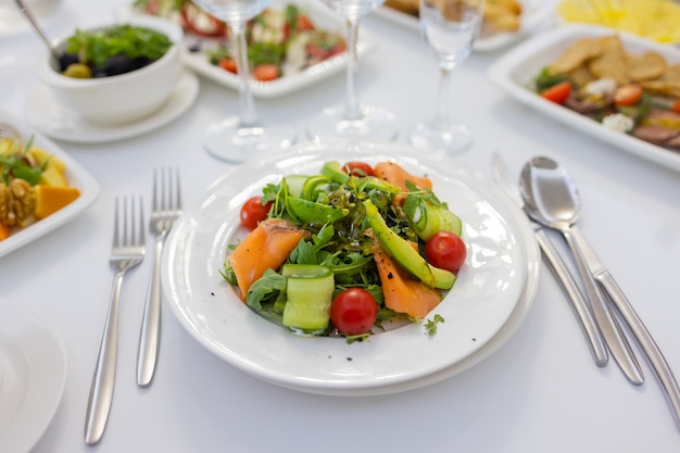 Fresh lamb lettuce salad with avocado, cucumber, salmon, cherry tomatoes. Dressing with honey, dijon mustard, olive oil and lemon juice, topped with chia seeds. Prepared by chef.