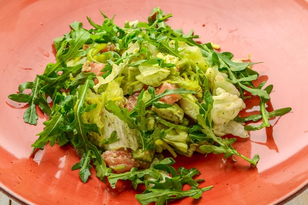 Fresh lamb lettuce salad with avocado, cucumber, salmon, cherry tomatoes. Dressing with honey, dijon mustard