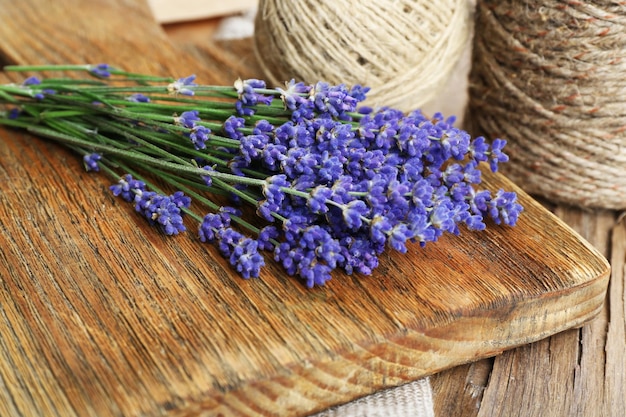 Fresh lavender and rope on wooden cutting board closeup