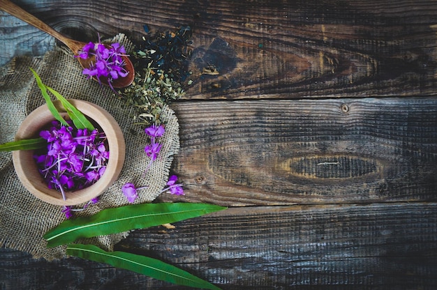 Fresh leaves and flowers of Ivan tea or fireweed on wooden background copy space concept of medicinal plants and folk medicine