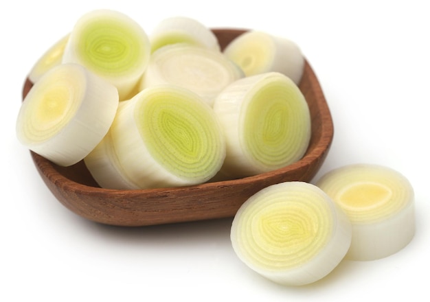 Fresh leek stem chopped in a bowl over white background