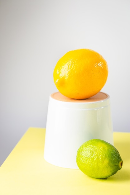 Fresh lemon and lime over two tone background yellow and white minimalist composition