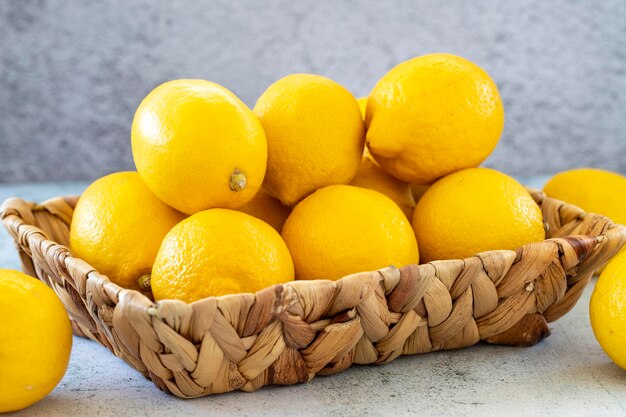 Fresh lemon Organic lemons in a basket on a stone background close up