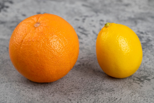 Fresh lemon with an healthy orange isolated on a stone table.