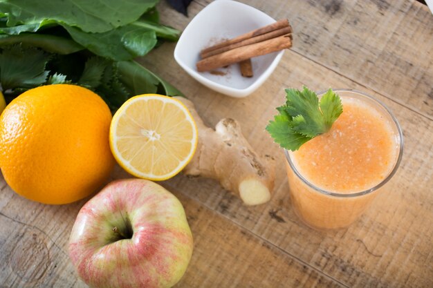 Fresh lemonade with ginger served on a table full with other fruits and cinnamon