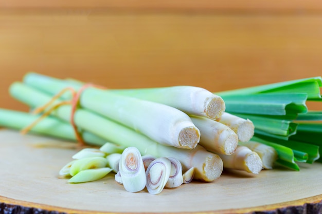 Fresh lemongrass rope and lemongrass slice on wooden cutting board in cooking concept.