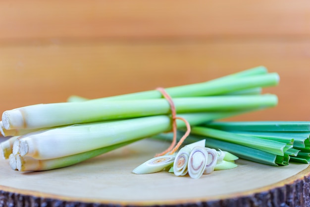 Fresh lemongrass rope and lemongrass slice on wooden cutting board in cooking concept.