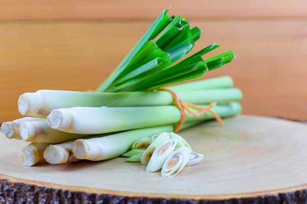 Fresh lemongrass rope and lemongrass slice on wooden cutting board in cooking concept.