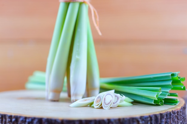 Fresh lemongrass rope and lemongrass slice on wooden cutting board in cooking concept.