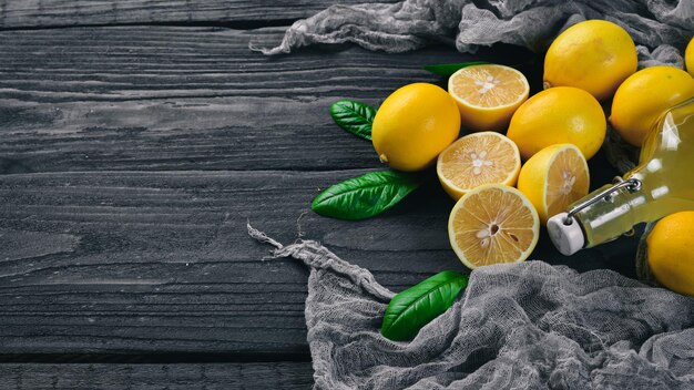 Fresh Lemons and Lemon Juice. On a wooden background. Top view. Free space for your text.