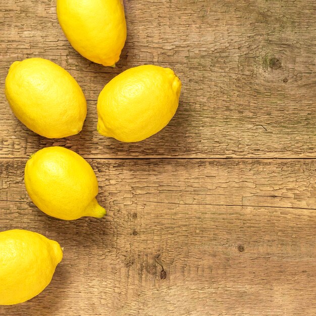 Fresh lemons on a wooden tableCopy space for text Top view