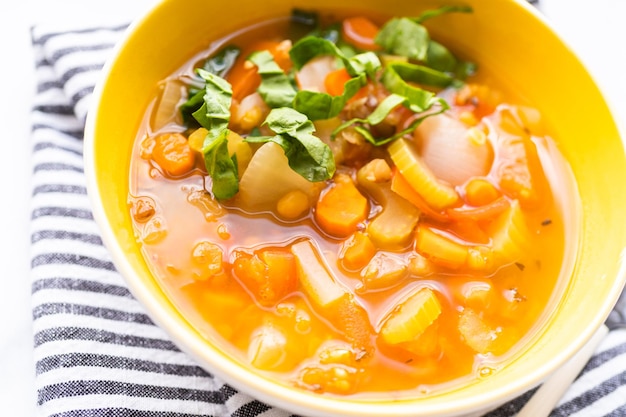 Fresh lentil soup garnished with fresh spinach in a bowl.