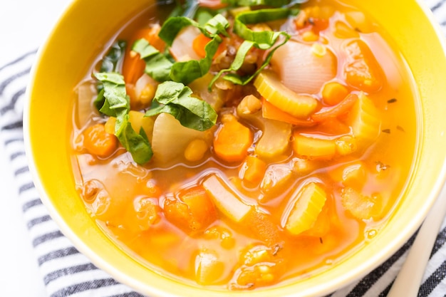 Fresh lentil soup garnished with fresh spinach in a bowl.