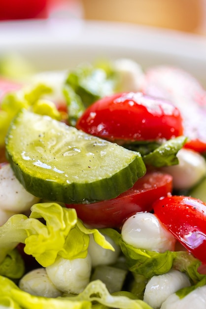 Fresh lettuce macro shot. Salad with baby mozzarella cherry leaves iceberg. Olive oil in salad.