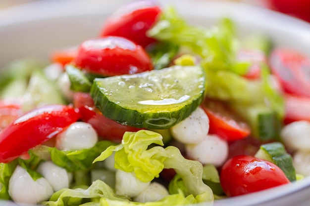 Fresh lettuce macro shot. Salad with baby mozzarella cherry leaves iceberg. Olive oil in salad.