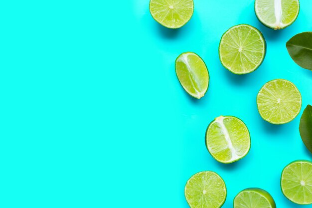 Photo fresh limes on blue background top view