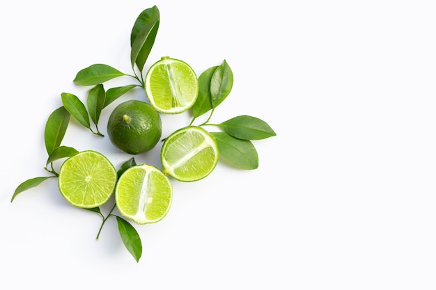 Fresh limes with green leaves on white background. Top view