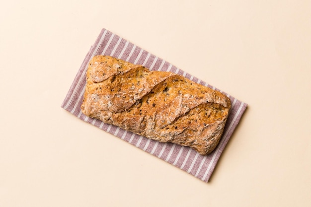 Fresh loaves of bread with wheat and gluten on a colored table bread on napkin on rustic background fresh bread top view