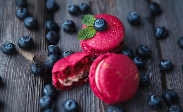 fresh macaroons and ripe blackberry on a wooden background