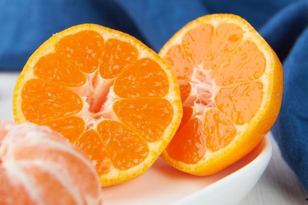 Fresh mandarin oranges fruit or tangerines with leaves on a wooden table