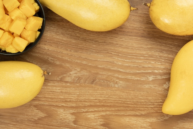 Fresh mango top view. wooden background and copy space for add text.