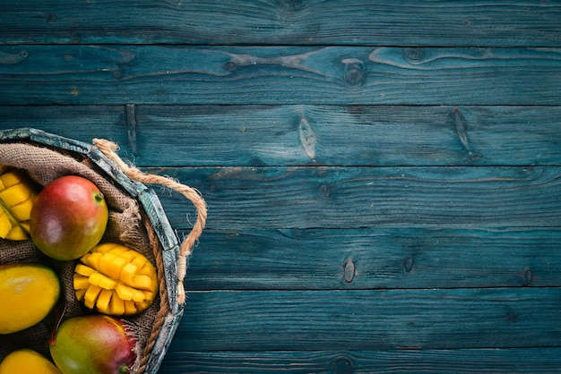 Fresh mango in a wooden box On a wooden background Tropical Fruits Top view Free copy space