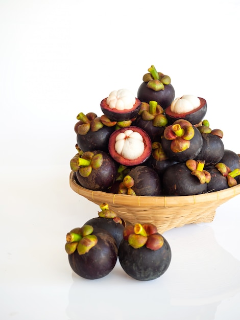 Fresh mangosteen in bamboo basket on white isolate. Healthy and sweet fruit. High vitamins.