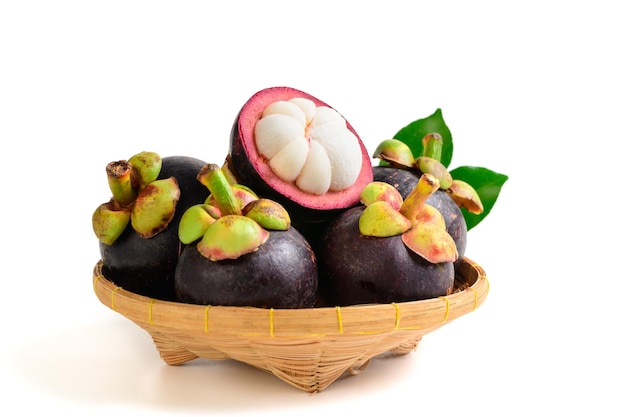 Fresh Mangosteen with leaves on bamboo basket isolated on white background