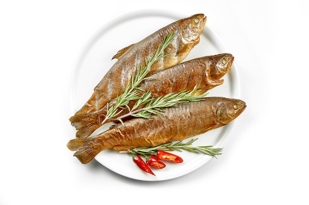 Fresh marinated in spices trout fish in a white plate White background selective focus