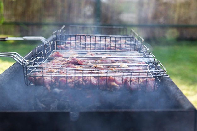 Fresh meat for barbecue fried on fire Selective focus Grilled pork meat Cooking barbecue on the grill with smoke Picnic in nature Healthy food and proper nutrition