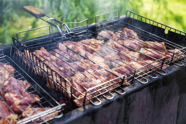 Fresh meat for barbecue fried on fire Selective focus Grilled pork meat Cooking barbecue on the grill with smoke Picnic in nature Healthy food and proper nutrition