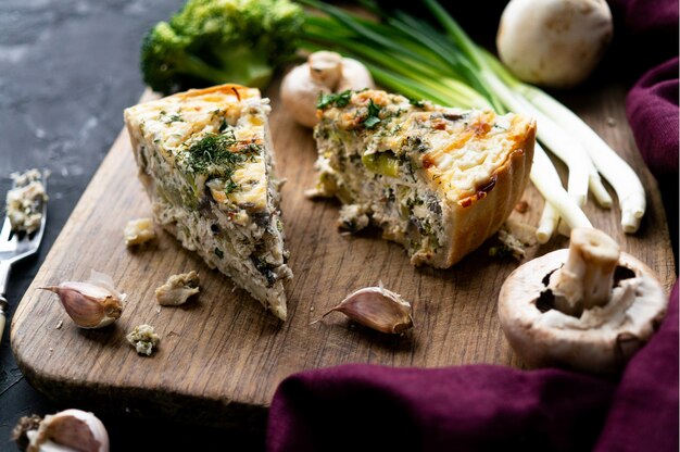 Fresh meat pie on a wooden board on a dark table background, close-up