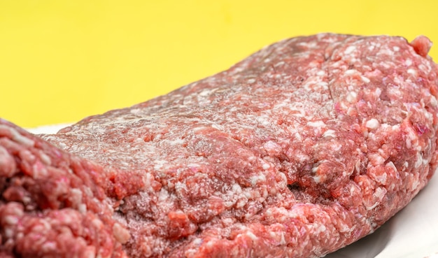 Fresh minced meat on yellow background