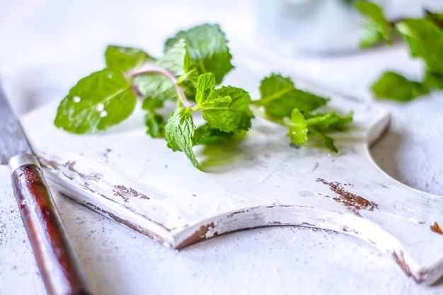 Fresh mint leaves on a cutting board with a knife