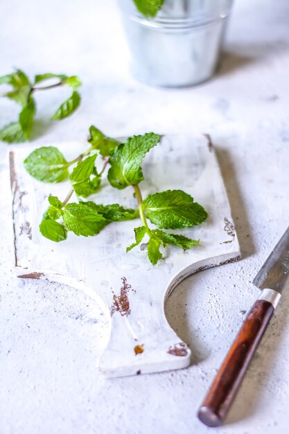 Fresh mint leaves on a cutting board with a knife