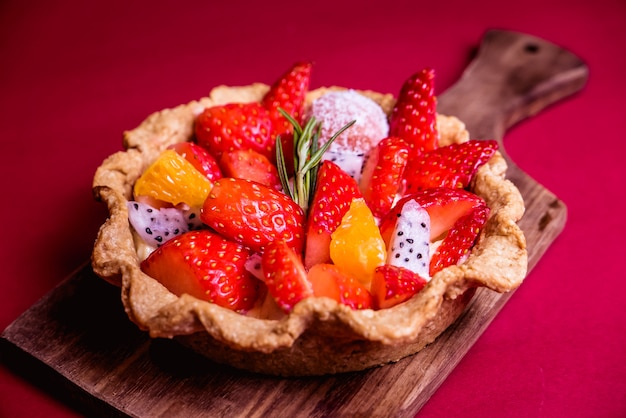 Fresh mixed Fruit Tart on red background