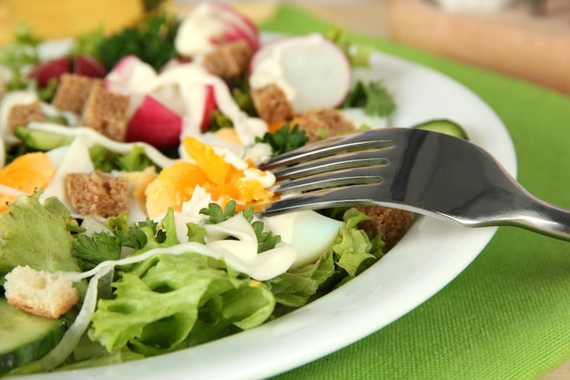 Fresh mixed salad with eggs salad leaves and other vegetables on bright background