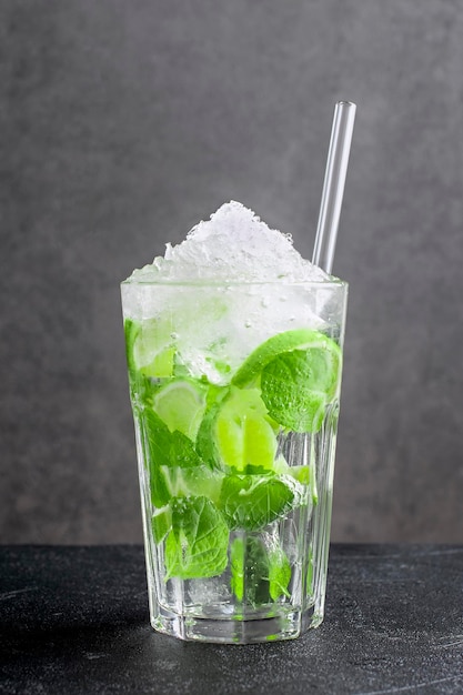 Fresh mojito made of citrus fruit and green mint leaves on dark background